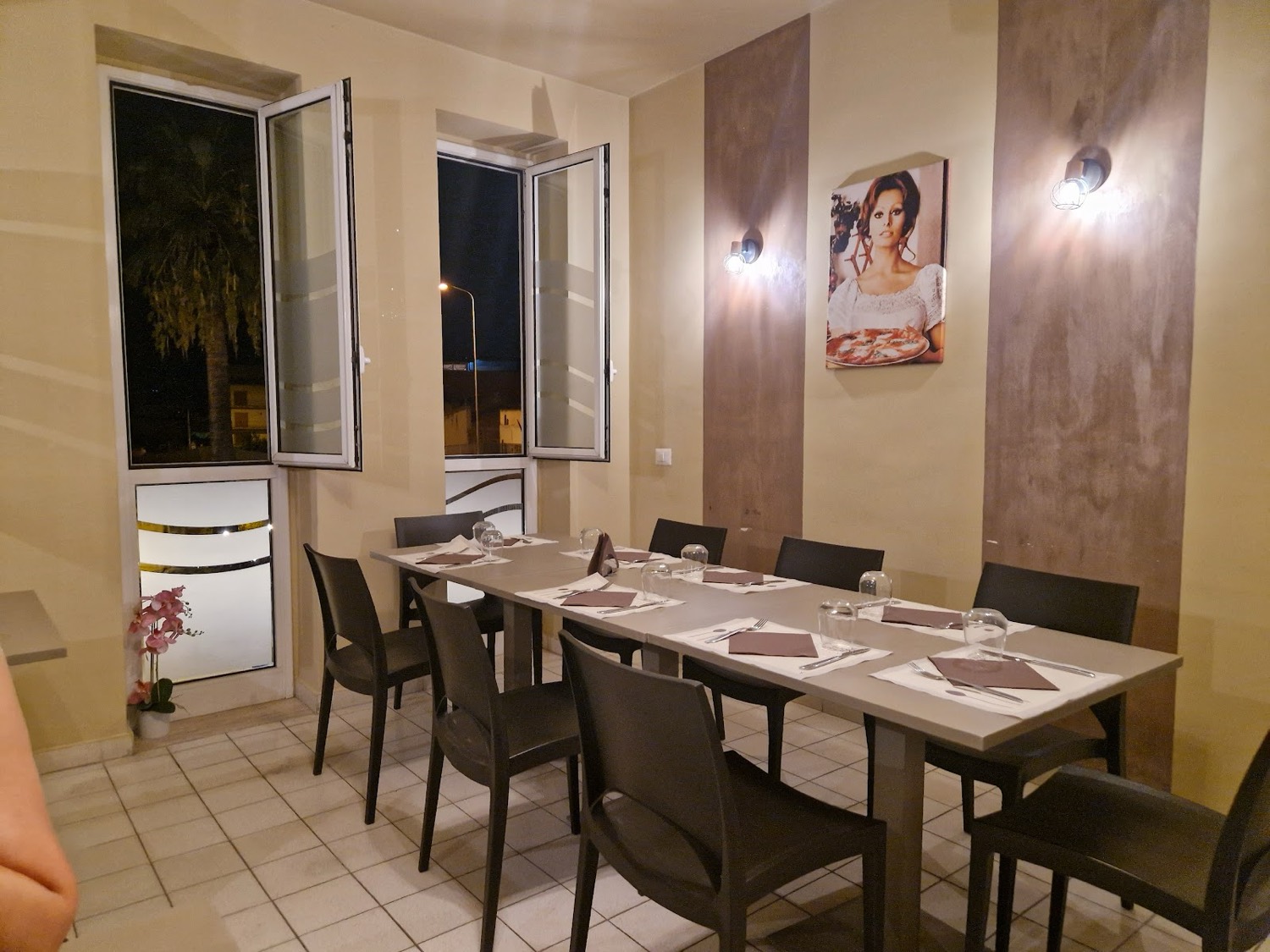 La sala di Bella Napoli, tavoli apparecchiati e pareti calde